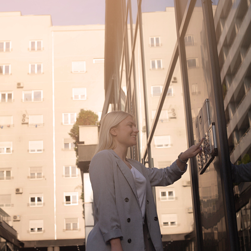 Image of woman using front door security intercom from a NC commercial security systems provided by Protection Systems, Inc.